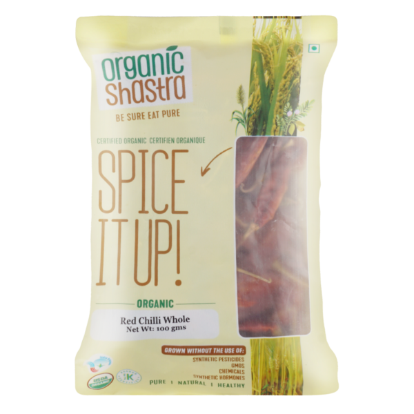 "Packaging of Organic Shastra Red Chilli Whole, 100 grams, featuring a clear window showing the chillies inside, with labels indicating it is certified organic and free from synthetic pesticides, GMOs, and other chemicals."