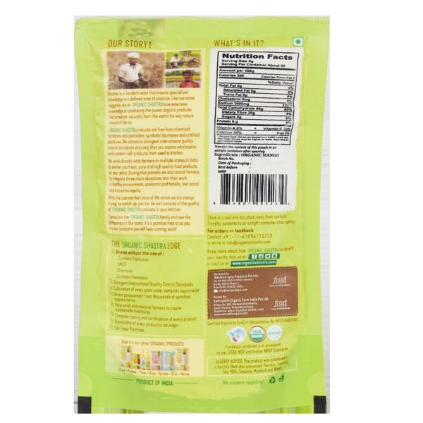 Back view of Organic Shastra Amchur Powder 100 gm pack. The packaging details the product's organic certification, nutritional facts, ingredient list (100% organic mango), and the brand's commitment to purity, natural ingredients, and sustainability. It also highlights the absence of synthetic pesticides, GMOs, chemicals, and synthetic hormones