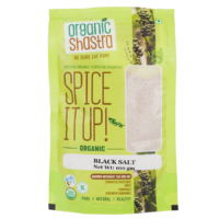 Organic Shastra Black Salt 100 gm package with green and yellow design, text reading 'Spice It Up! Organic Black Salt', 'Be Sure Eat Pure', and highlighting certification as organic and free from synthetic pesticides, GMOs, chemicals, and synthetic hormones."